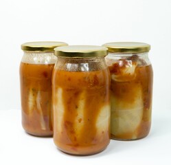 Glass jars of stuffed cabbage tomato sauce isolated on a white background
