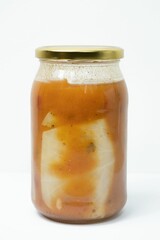 Glass jar of stuffed cabbage tomato sauce isolated on a white background