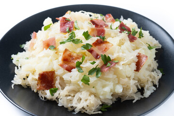 Slovak potato dumplings halusky with steamed sauerkraut and bacon isolated on white background....