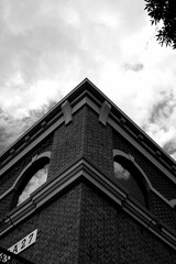 Vertical low angle grayscale of a angle of a building under the cloudy sky