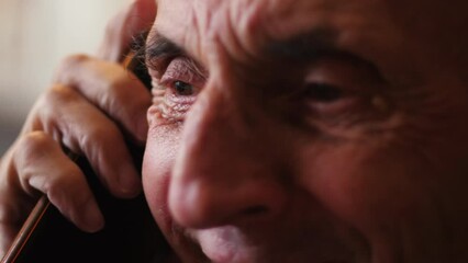 portrait of a cheerful Caucasian pensioner 70 -79 years old talking on the phone. emotions of older people. cheerful pensioner jokes while talking on the phone
