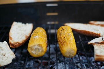 Close-up shot of corns and bread slices on a grill stove