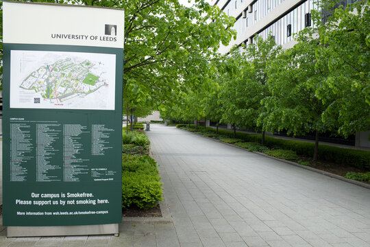University Of Leeds campus map sign besides tree line pavement. Leeds, UK 05 08 2024 