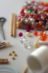 Various craft supplies on white background. Supplies for jewelry making, drawing and needlework. Selective focus.