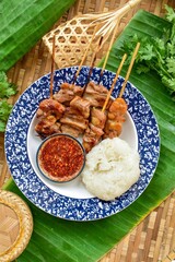 grilled pork and sticky rice  thai style on banana leaf, top view, thai called Moo ping	, bbq pork