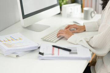 Cropped shot businesswoman typing on computer keyboard, answering business email