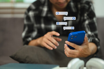 Smiling young man reading text message or notification on his smartphone