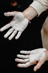 Closeup of flour-stained cook's hands against the black background
