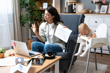 Multitasking mother. Young freelance business mom taking care of her child, young baby, and working...