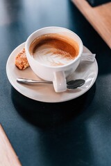 Closeup of a Flat White in a white cup over a black table