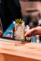 Vertical closeup of the bartender serving a mojito.