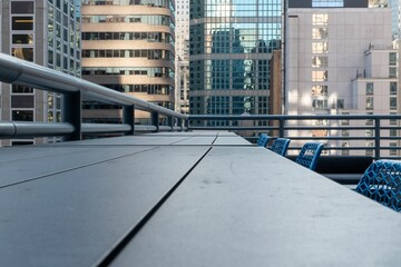 Fototapeta premium Chairs near a table on the roof of a building against other buildings in an urban city