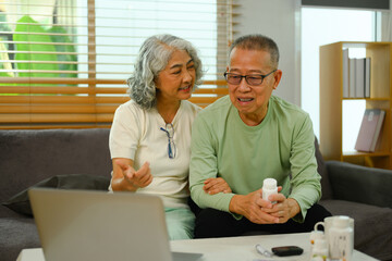 Mature couple making video call with their doctor on laptop at home. Telehealth concept