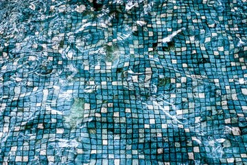 Blue and white grid pattern of the bottom of a pool.