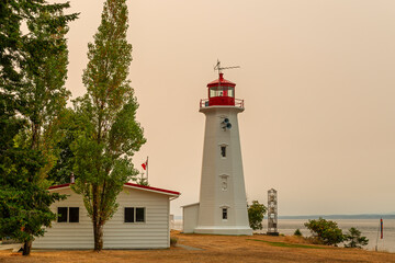 Cape Mudge lighthouse with red glow of forest wildfires, Quadra Island, British Columbia, Canada.