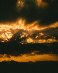 Beautiful view of the sunset gleaming in the cloudy sky