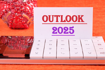 Economic outlook concept. Financial, business. OUTLOOK 2025 text on a white business card with a...