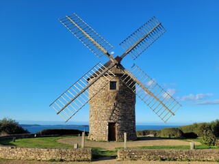 Aerial view of Moulin de Craca mill on blue sky background in Plouezec, France