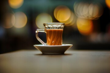 Transparent cup of Tea with Bokeh lights on the background
