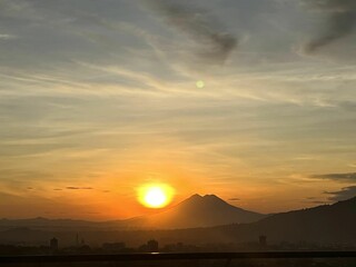 Fototapeta premium Beautiful shot of a landscape with mountains under the orange sun