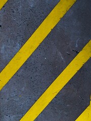 Fototapeta premium Vertical closeup shot of yellow markings on the street