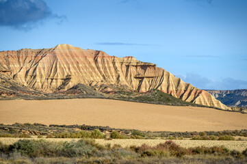 Desert landscape with farmland in front, Bardenas reales national park, Navarro, Spain.