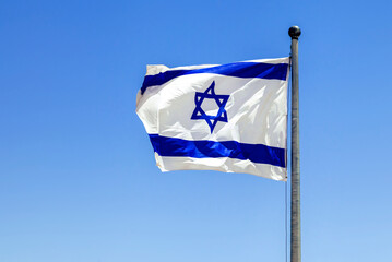 The Israeli flag waving in the bright sunlight