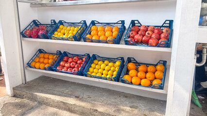 a display rack of fresh fruit including oranges apples pineapple Sunkist and orange street stall