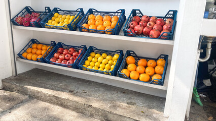 a shelf of fruit including apples oranges and lemons pineapple juice bar concept store interior