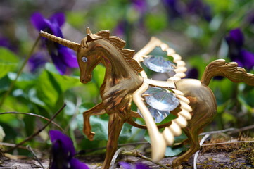 A unicorn statuette with wings decorated with decorative glass.