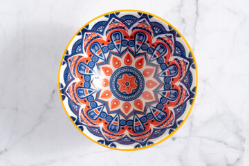 A small rounded shaped crockery ceramic bowl with vintage art designed. Top View
