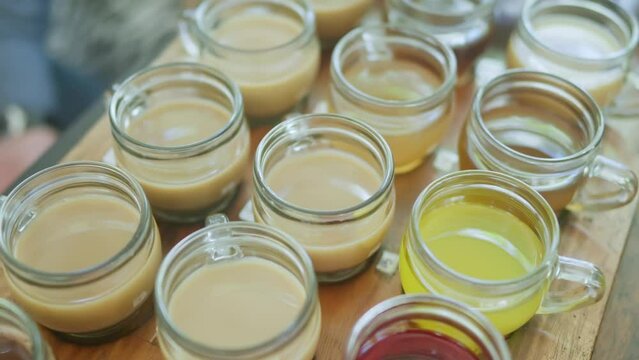 Close-up view of tourists tasting various coffee and tea drinks at a kopi luwak farm in Bali. 4K video.
