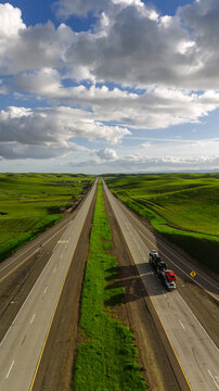 Highway in the middle of a picturesque green field and sky. View from above. Drone photo