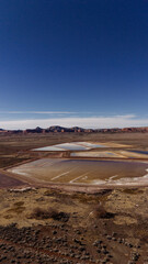 Landscape photo with a lake in the desert with mountains in the background