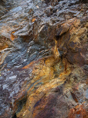 Quartzite veins at the Fusafjorden and Samnagerfjord on the West-coast of Norway. The colors are include orange, ocher, brown and purple. In the middle of the photo it looks like there is an eye in it