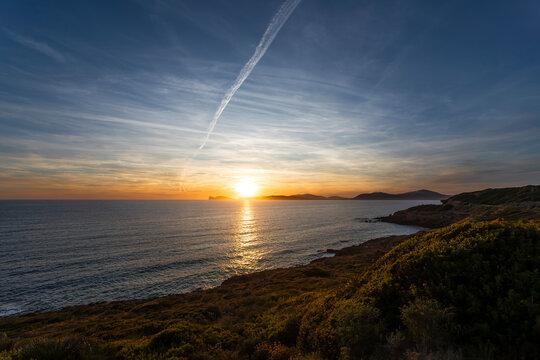 Sun goes down behind Capo Caccia in the north of Sardinia, Italy
