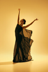 Simplicity and beauty of the dance. Full-length image of elegant woman, ballerina in black costume...