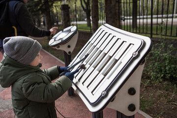 A little boy of 4 years old walks and plays on the playground. Childhood and child development.