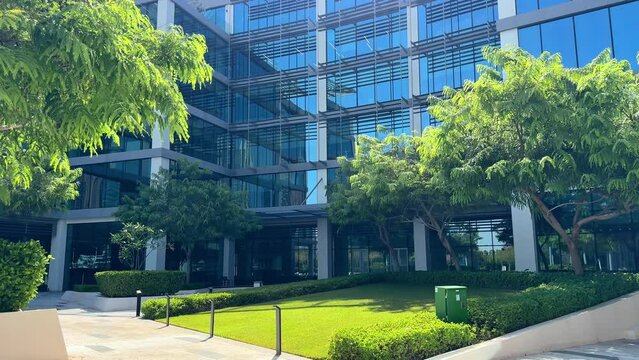 Modern glass office building exterior with reflection in the windows. Bottom up view. Wide angle shot. High quality 4k footage