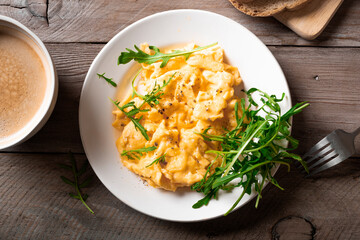 Scrambled eggs with arugula salad for breakfast.