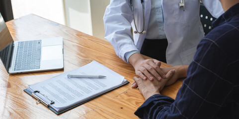 Close-up view of a female doctor giving advice and encouragement to a stressed young patient with...