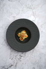 Wasabi shrimp served on a black plate on table