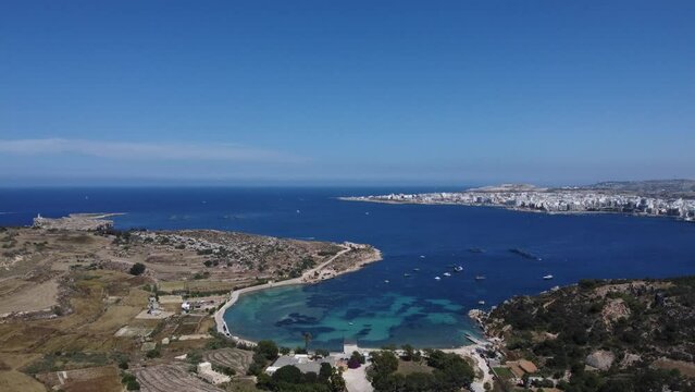 Mistra bay and Selmun peninsula agricultural terraced fields, secluded beach view from the Selmun palace. Aerial shot. St Pauls islands, Qawra and Bugibba in the distance. High quality 4k footage