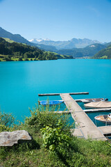 turquoise lake Lungernsee, with boardwalk and boats. landscape switzerland
