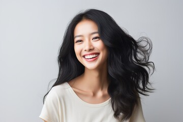 Naklejka premium A woman with long hair is smiling and wearing a white shirt