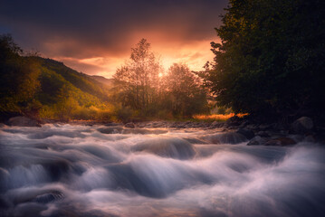 beautiful sunrise over fast flowing mountain river