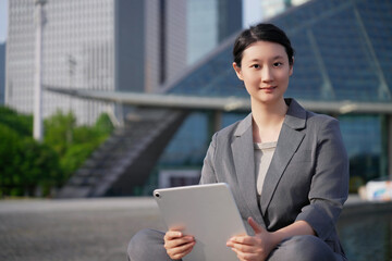 Confident Businesswoman with Tablet in Urban Setting