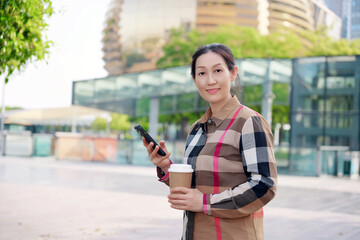 Confident Young Woman with Coffee and Smartphone in the City
