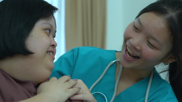 Asian female doctor Supporting patients with Dow Syndrome at home.
