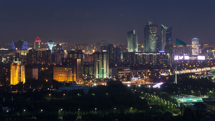 Fototapeta premium Elevated night view over the city center and central business district with bayterek Timelapse, Kazakhstan, Astana